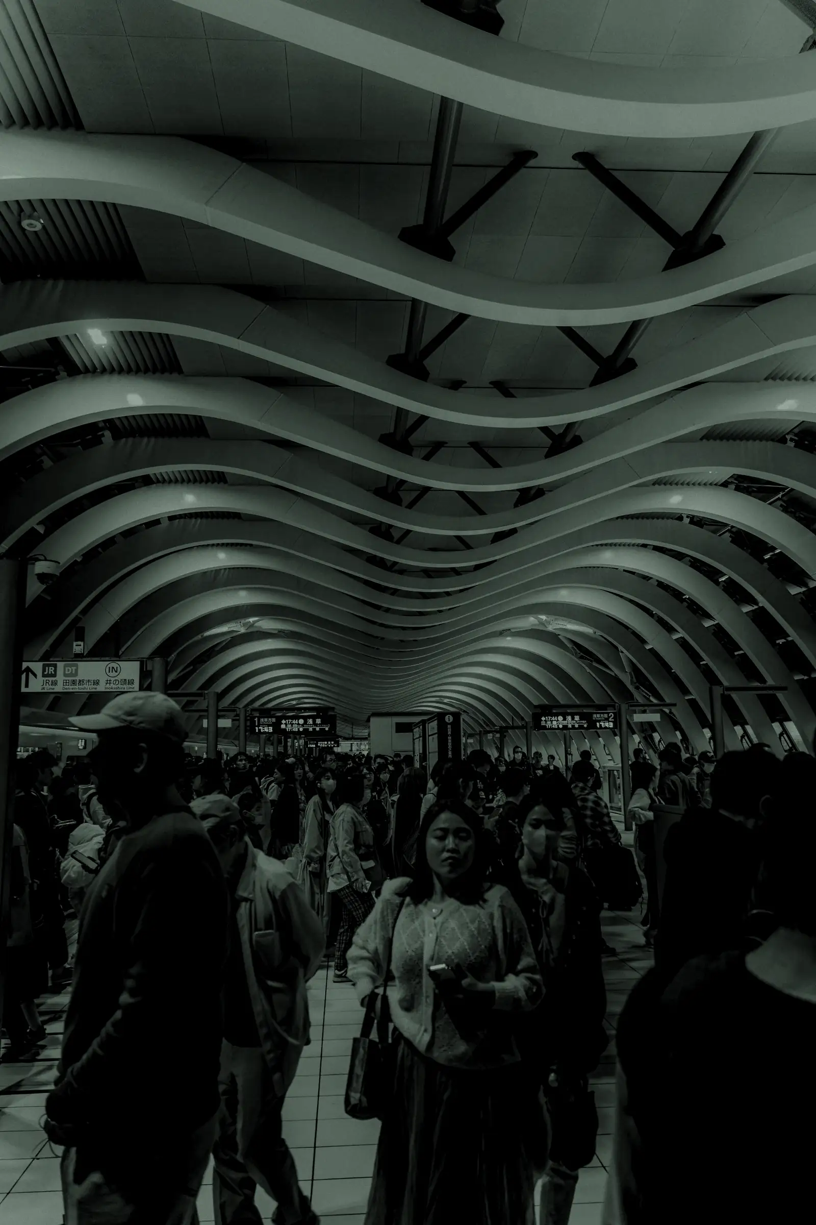 Travellers in a large transit hall under a curved ceiling