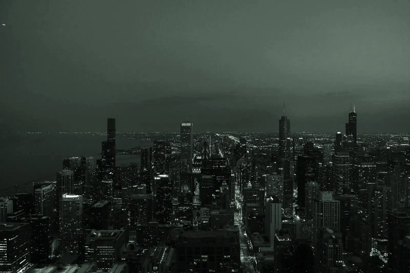 A city skyline at dusk with lit streets between office towers